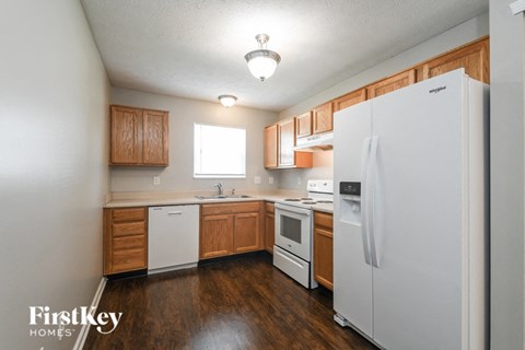 a kitchen with white appliances and wooden cabinets