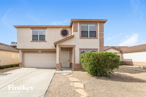 a beige house with a driveway and a garage door