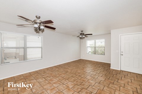 a living room with two ceiling fans and a window