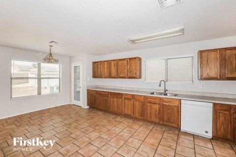 a large kitchen with wooden cabinets and a sink