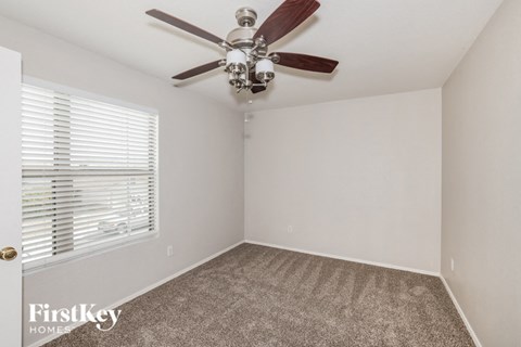 a bedroom with a ceiling fan and a window