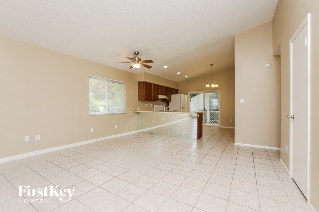 an empty kitchen and living room with a ceiling fan