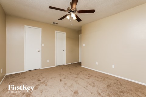 a living room with carpet and a ceiling fan