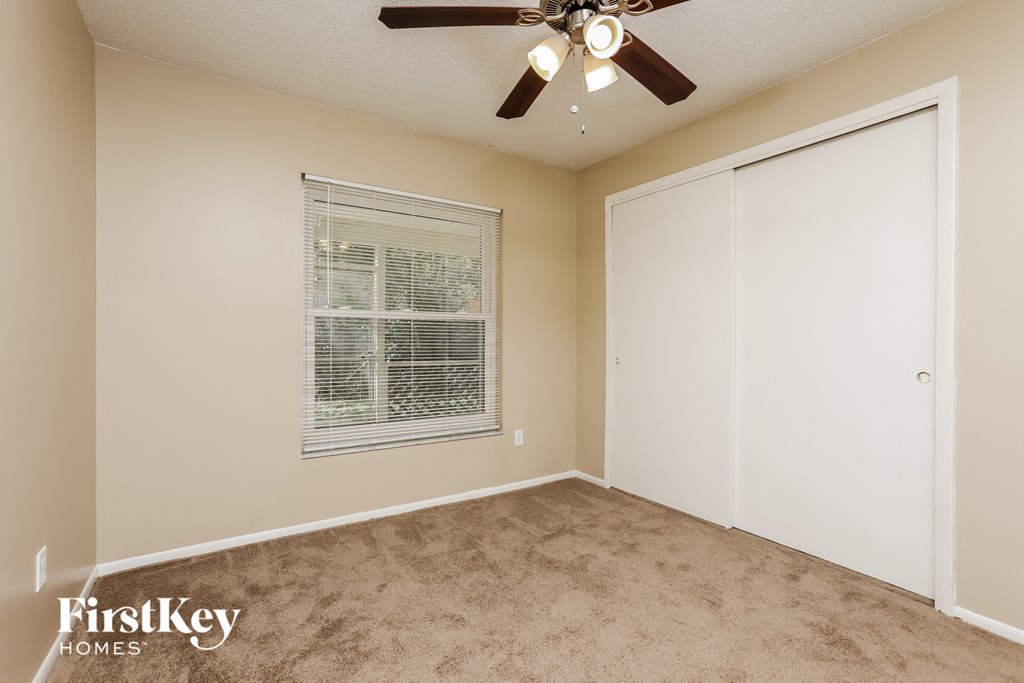 a bedroom with a ceiling fan and a closet