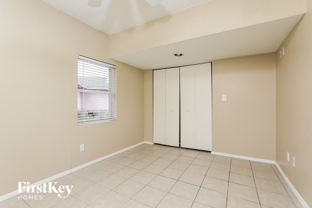 an empty room with white cabinets and a window