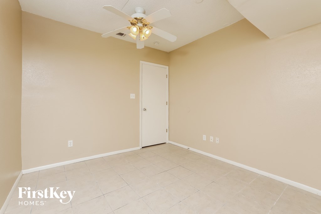 the living room of an empty house with a ceiling fan