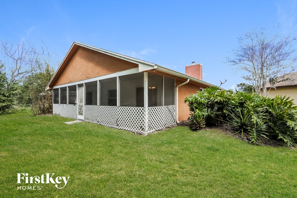the front of a house with a porch and a lawn
