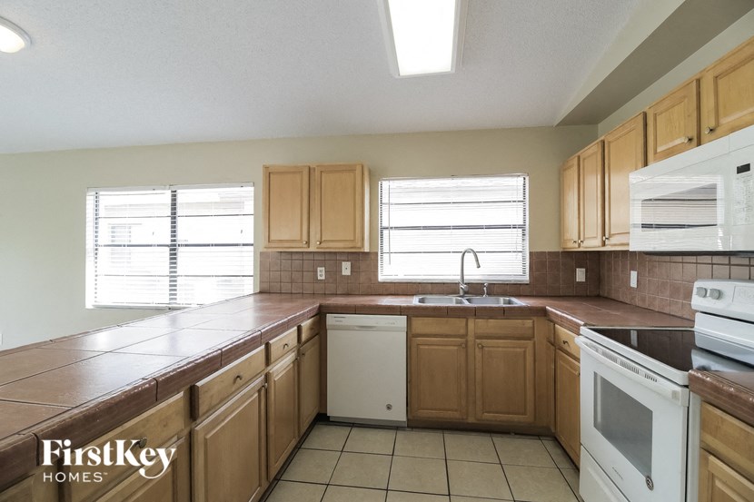 A kitchen with wooden cabinets and white appliances.