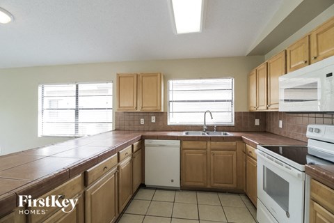 A kitchen with wooden cabinets and white appliances.