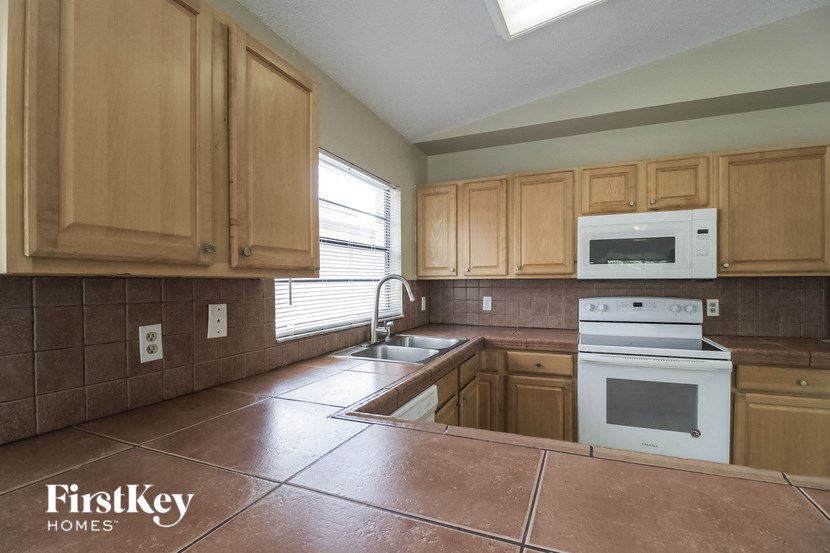A kitchen with wooden cabinets and a white oven.