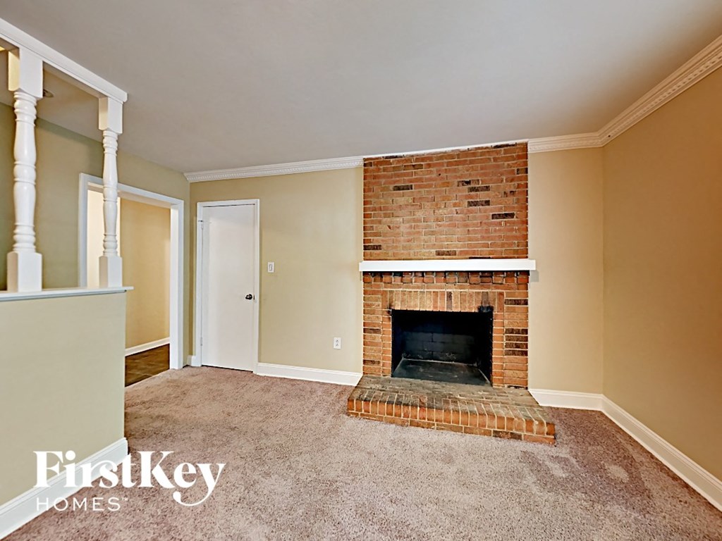 an empty living room with a brick fireplace