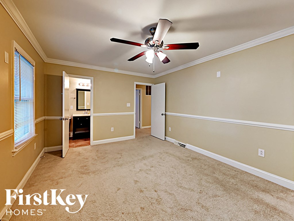 an empty living room with a ceiling fan