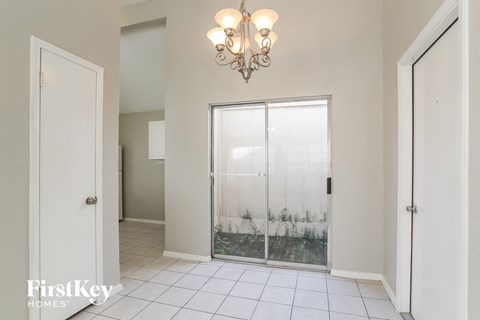 the entrance to the laundry room with a glass door and a chandelier