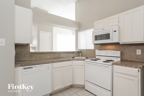 a kitchen with white appliances and white cabinets