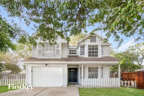 A two-story house with a white garage door and a black front door.
