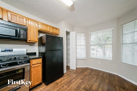A kitchen with wooden cabinets and black appliances.