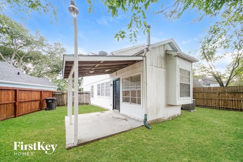 A house with a white exterior and a covered patio area is for sale.