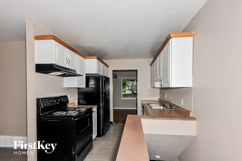 a kitchen with white cabinets and black appliances and a black stove