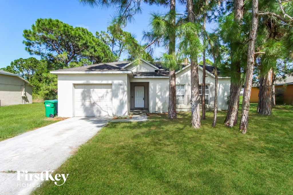 a small white house with palm trees in front of it