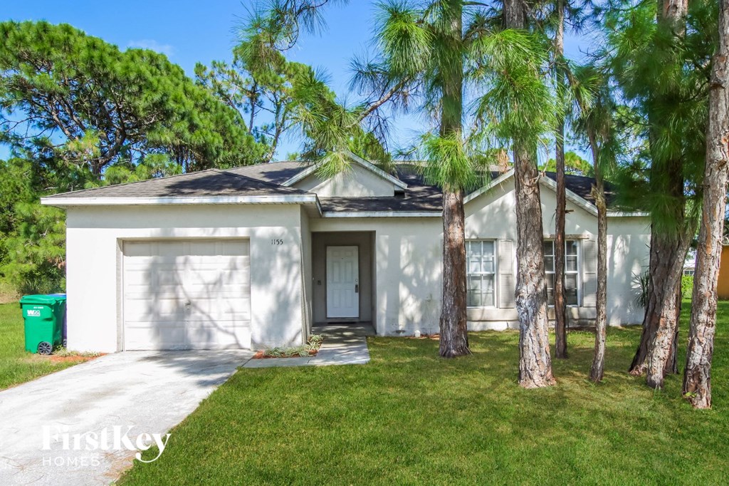 a white house with palm trees in front of it