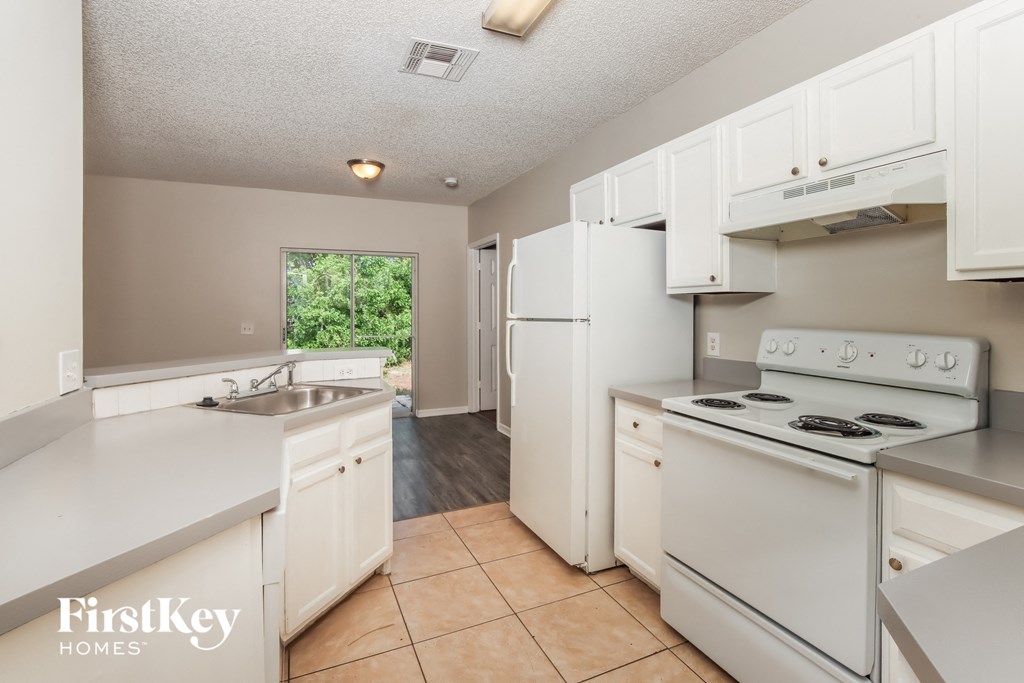 a kitchen with white appliances and white cabinets