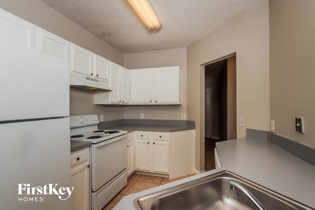 a kitchen with white appliances and counters and white cabinets