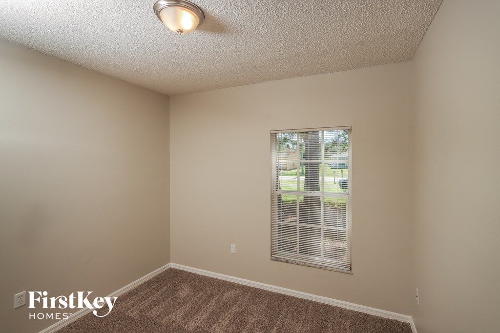 the living room of an empty home with a large window