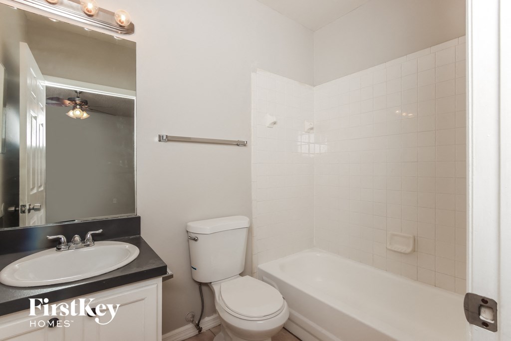 a bathroom with a toilet sink and tub and a mirror