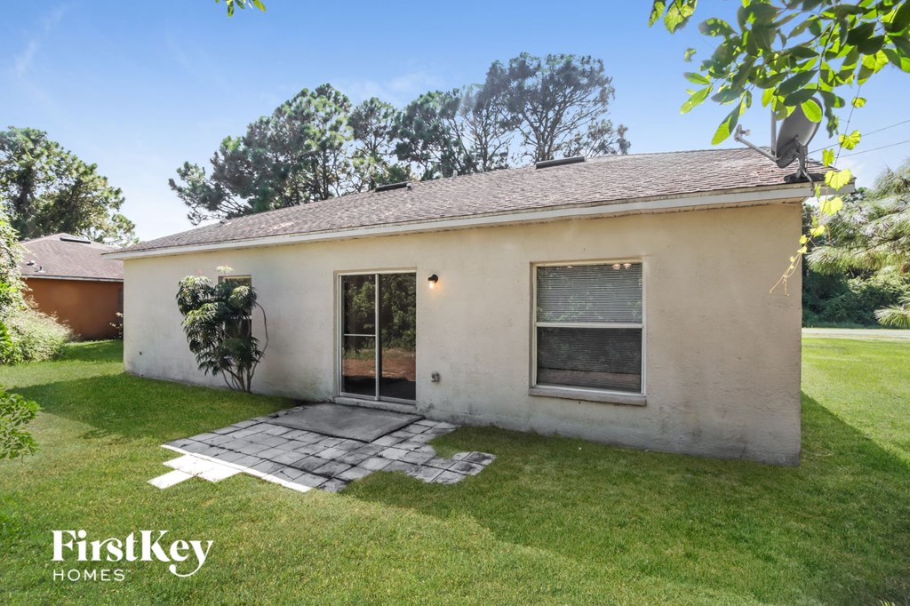 a small white house with a yard and grass