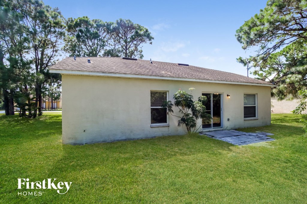 a small white house with a yard and grass