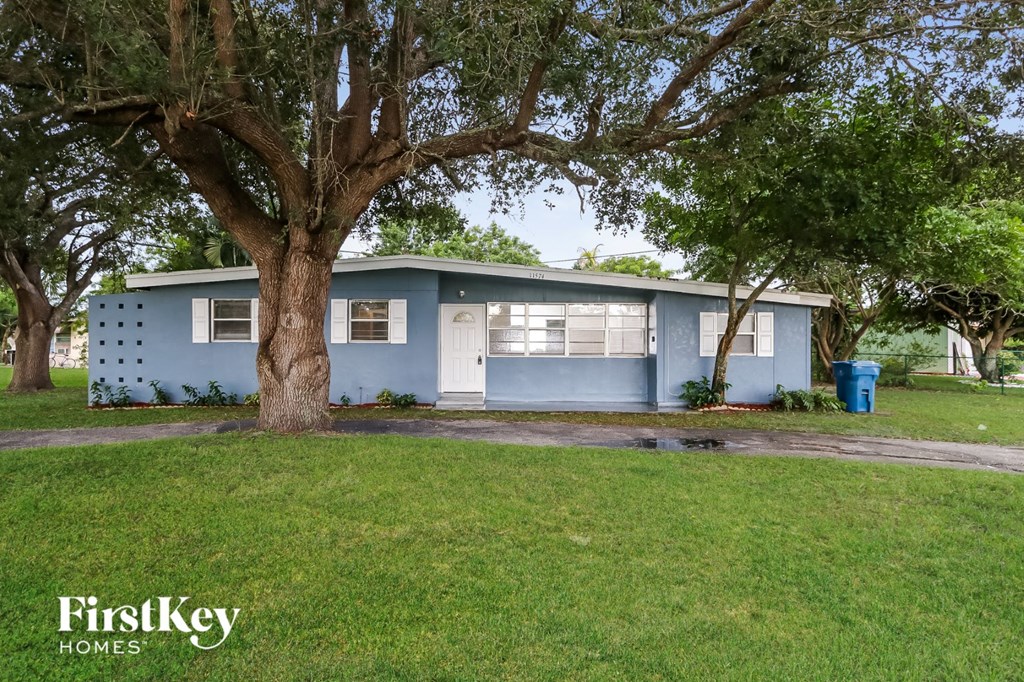 A blue house with a tree in front of it.