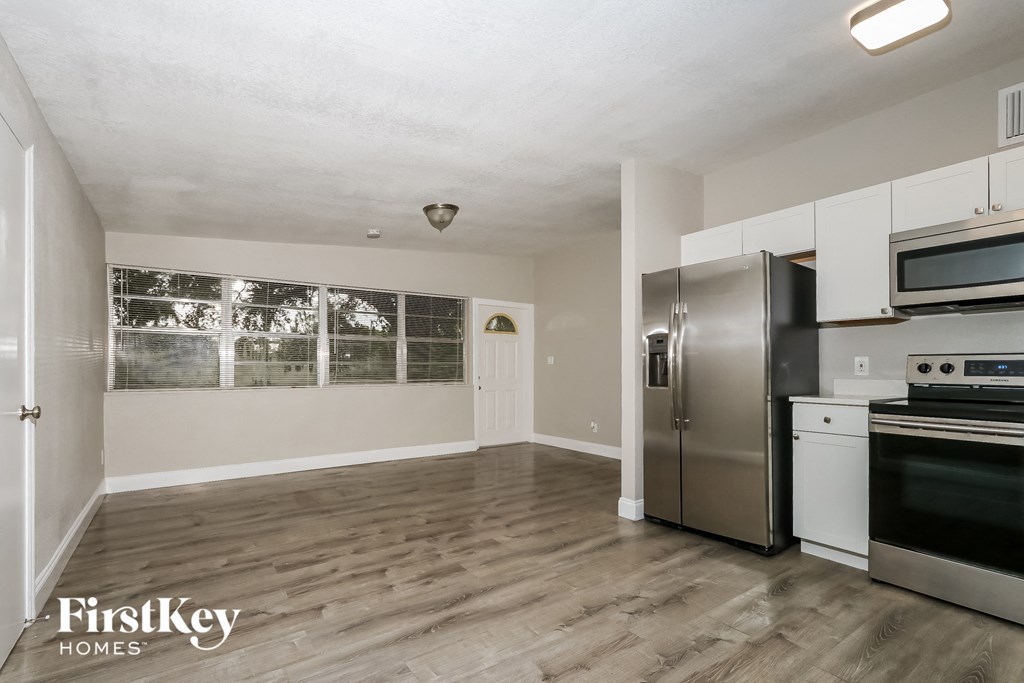 A kitchen with a refrigerator, oven, and microwave.