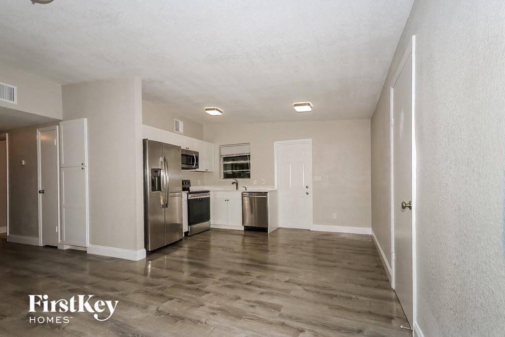 A kitchen area with a refrigerator, oven, and sink.