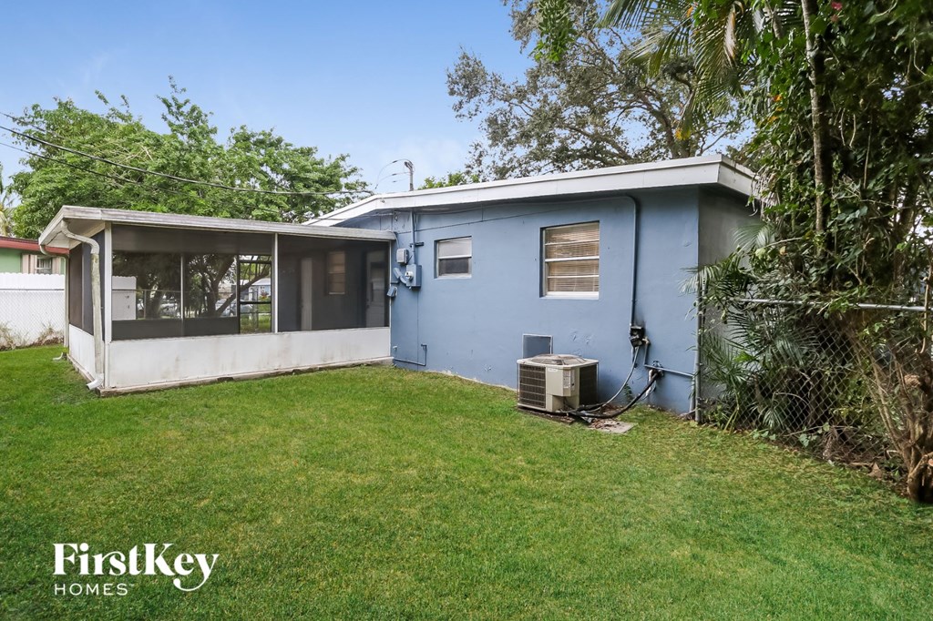 A blue house with a white roof and a green lawn.