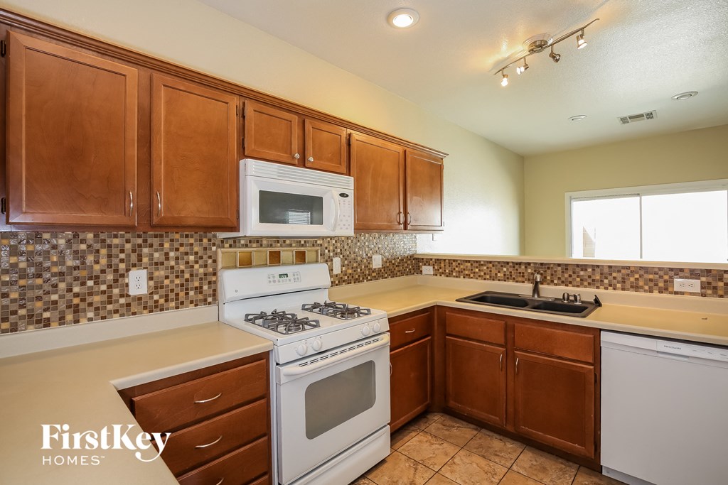 a kitchen with white appliances and wooden cabinets