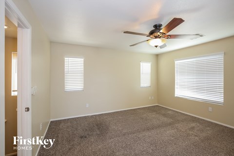a living room with carpet and a ceiling fan