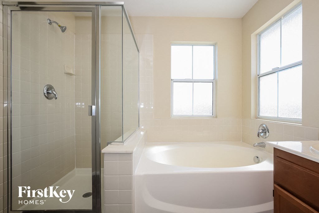a bathroom with a tub and a shower and a sink