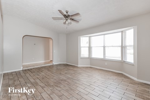 a living room with wood floors and a ceiling fan