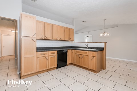 a kitchen with wooden cabinets and a black counter top