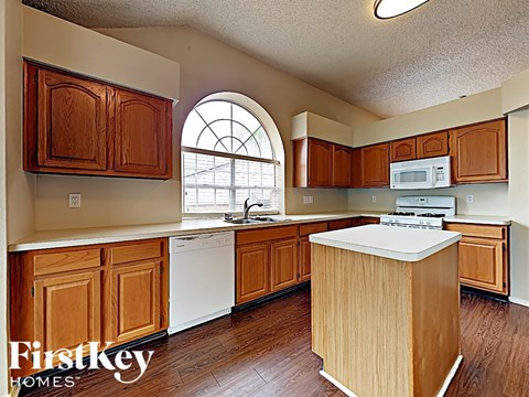 A kitchen with wooden cabinets and a white dishwasher.