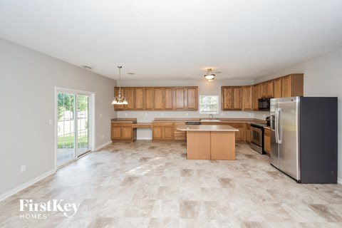 A kitchen with wooden cabinets and a tiled floor.