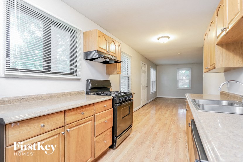 A kitchen with wooden cabinets and a stove top oven.
