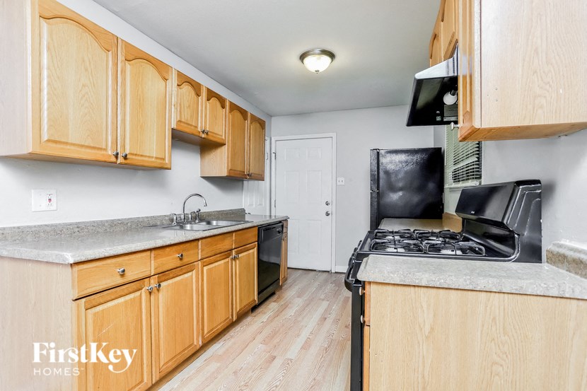 A kitchen with wooden cabinets and a granite countertop.