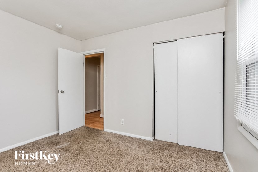 A room with a carpeted floor and a sliding door.