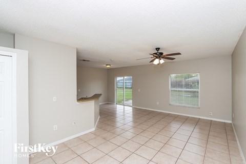 A spacious room with a ceiling fan and tiled floor.