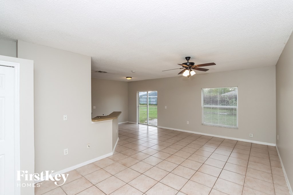 A spacious room with a ceiling fan and tiled floor.