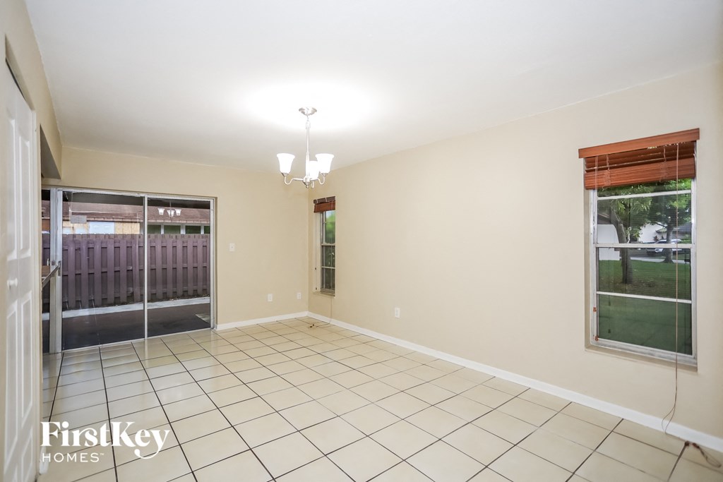 an empty living room with a door to a yard and a tile floor