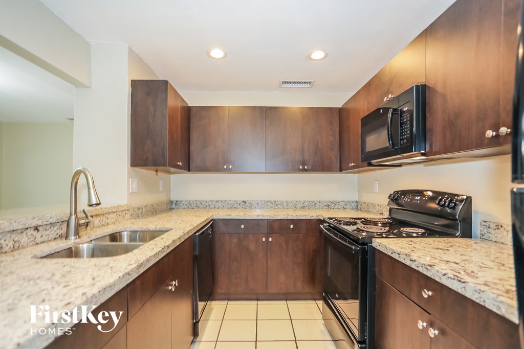 a kitchen with wood cabinets and granite counter tops and a sink and stove