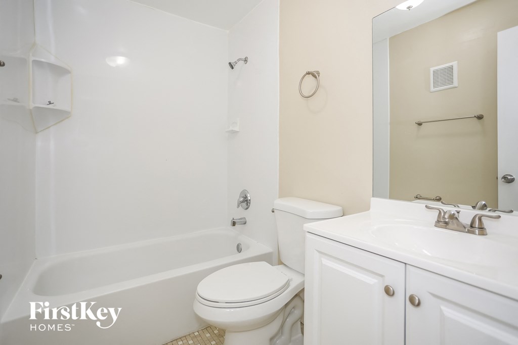 a white bathroom with a sink toilet and shower