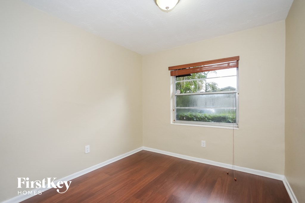 an empty room with wood floors and a window